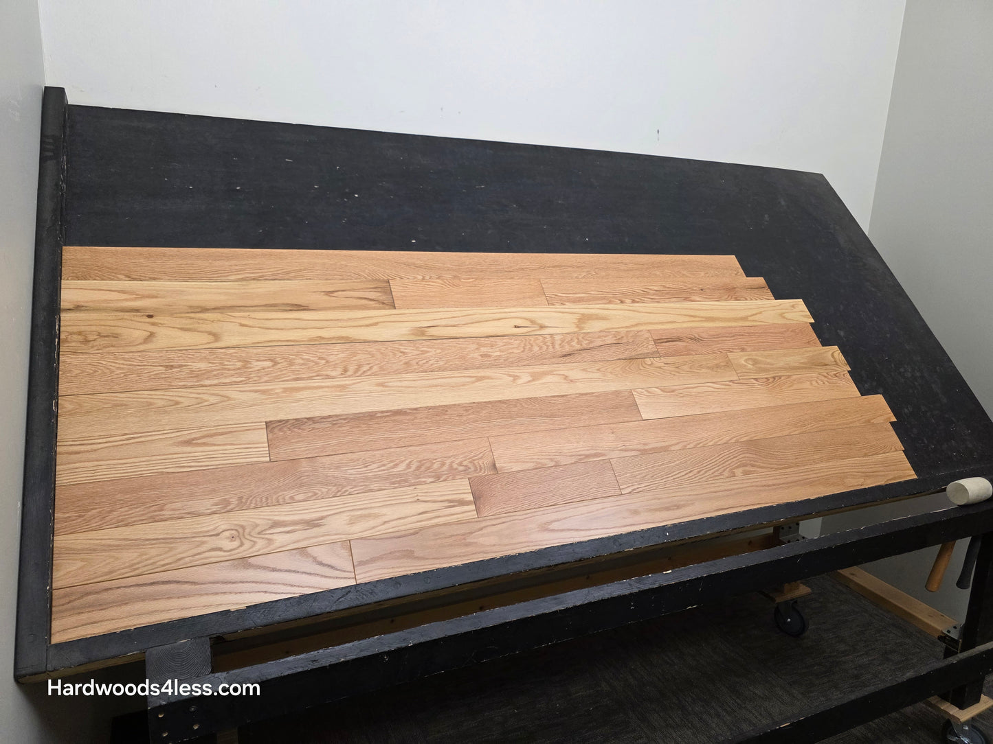 3 1/4" x 3/4" Red Oak Natural Common & Better Low Gloss Hardwood Flooring. shown on a black shooting table. Shot from center. 