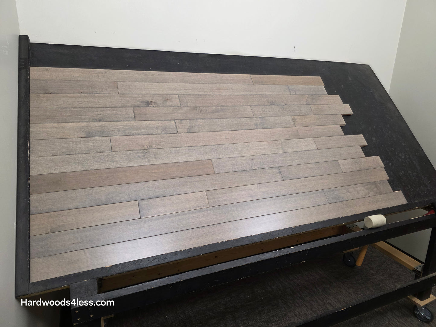 3 1/4" x 3/4" Solid Maple Dove Hardwood Flooring. Shown on a black shooting table. shot from left. 