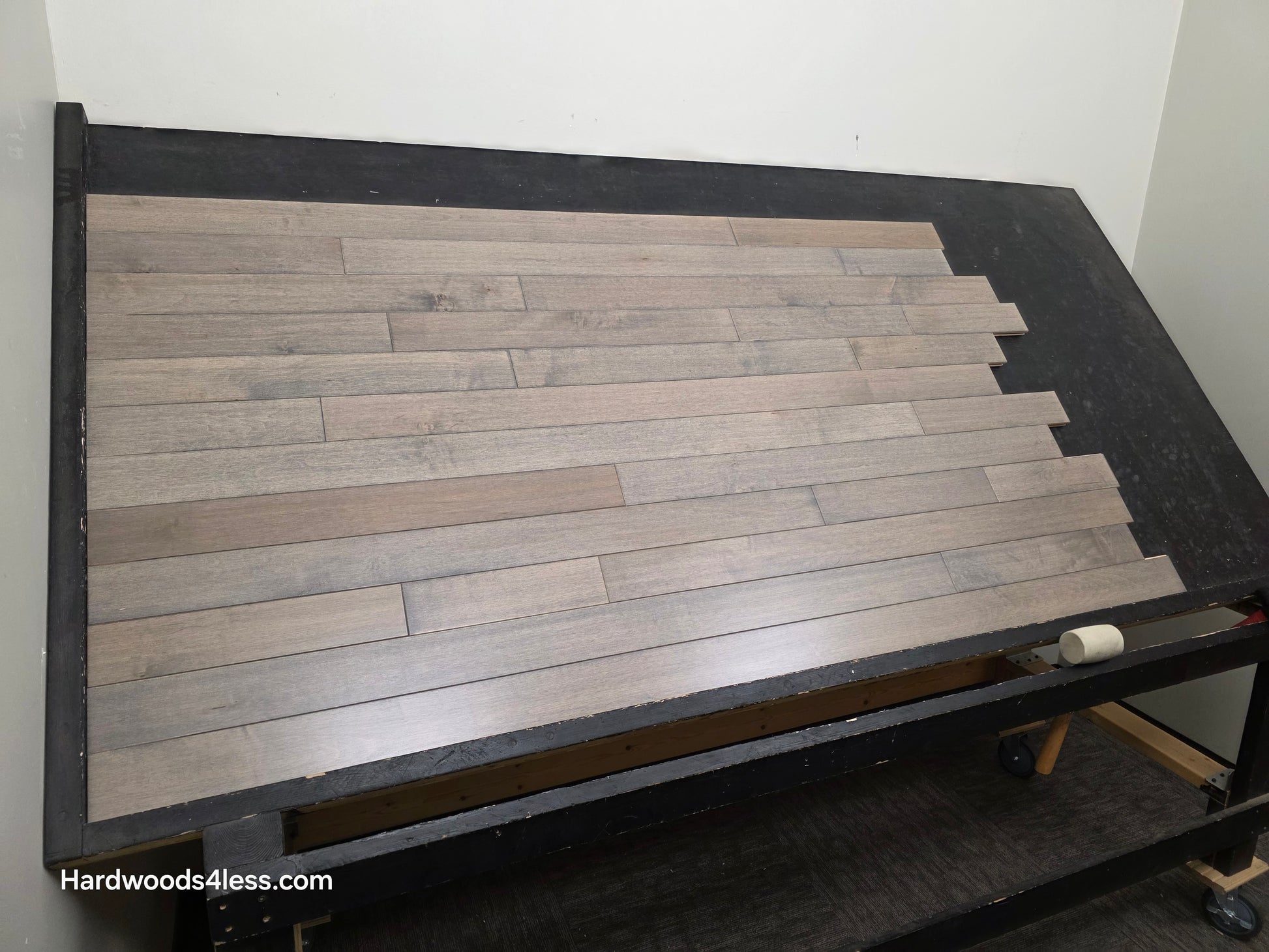 3 1/4" x 3/4" Solid Maple Dove Hardwood Flooring. Shown on a black shooting table. shot from left. 