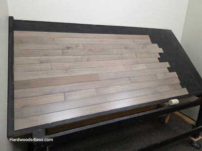 3 1/4" x 3/4" Solid Maple Dove Hardwood Flooring. Shown on a black shooting table. shot from left. 
