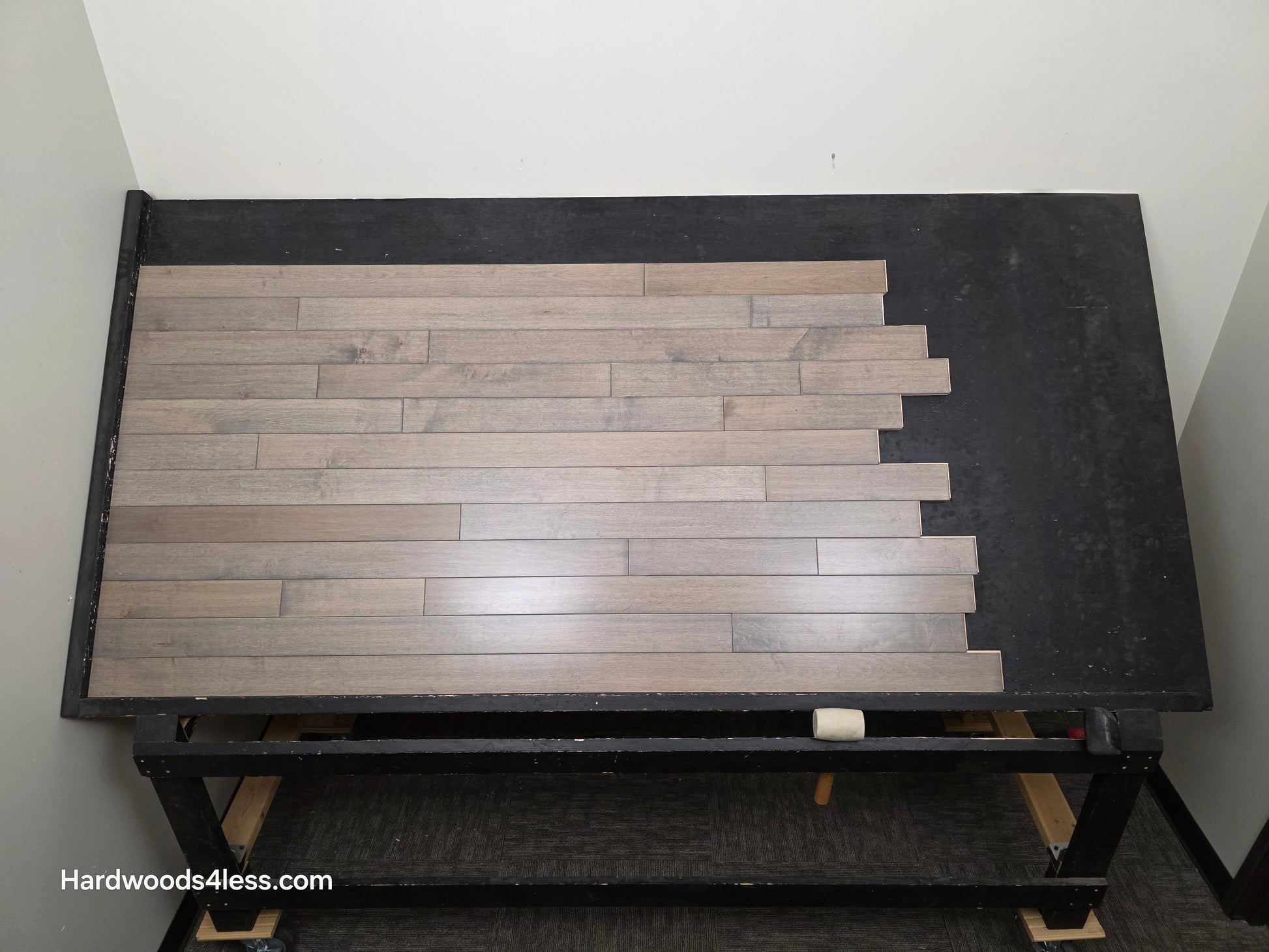 3 1/4" x 3/4" Solid Maple Dove Hardwood Flooring. Shown on a black shooting table. Shot from wide center. 