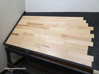 3 1/4" x 3/4" Solid Maple Natural Rustic Shorts Hardwood Flooring. Shown on a black shooting table. Shot from wide right.