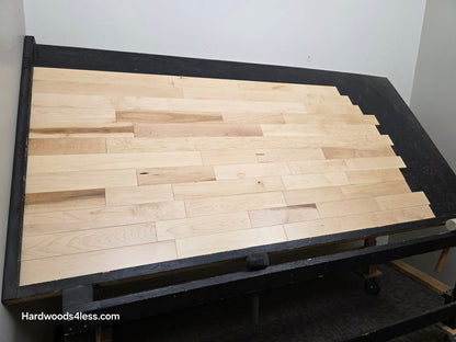 3 1/4" x 3/4" Solid Maple Natural Rustic Shorts Hardwood Flooring. Shown on a black shooting table. Shot from wide right.