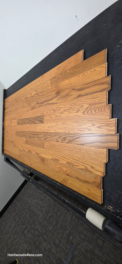 3 14 x 34 Solid Red Oak Blake Hardwood Flooring. Shown on a black shooting table shot from the right side.