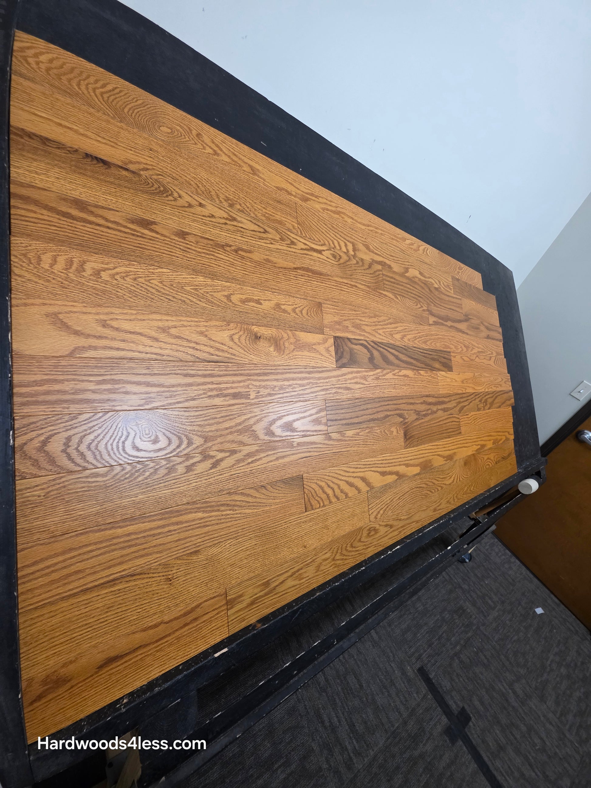 3 14 x 34 Solid Red Oak Blake Hardwood Flooring. Shown on a black shooting table shot steep from the left side.