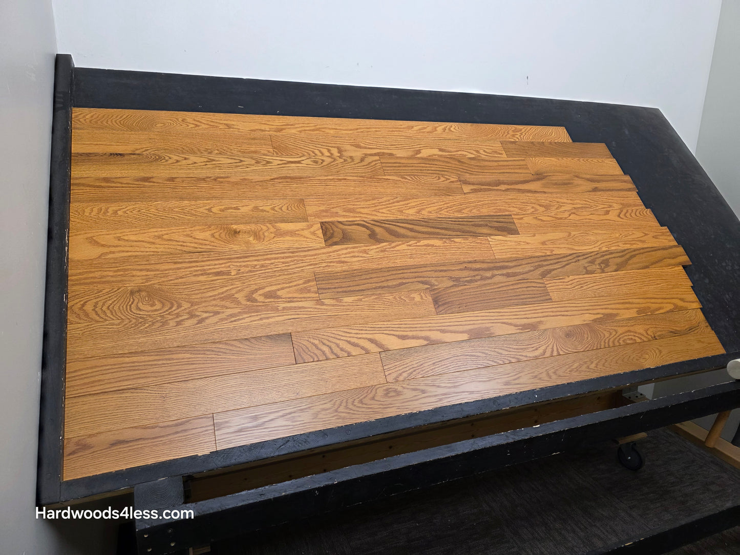 3 14 x 34 Solid Red Oak Blake Hardwood Flooring. Shown on a black shooting table shot from the left side.