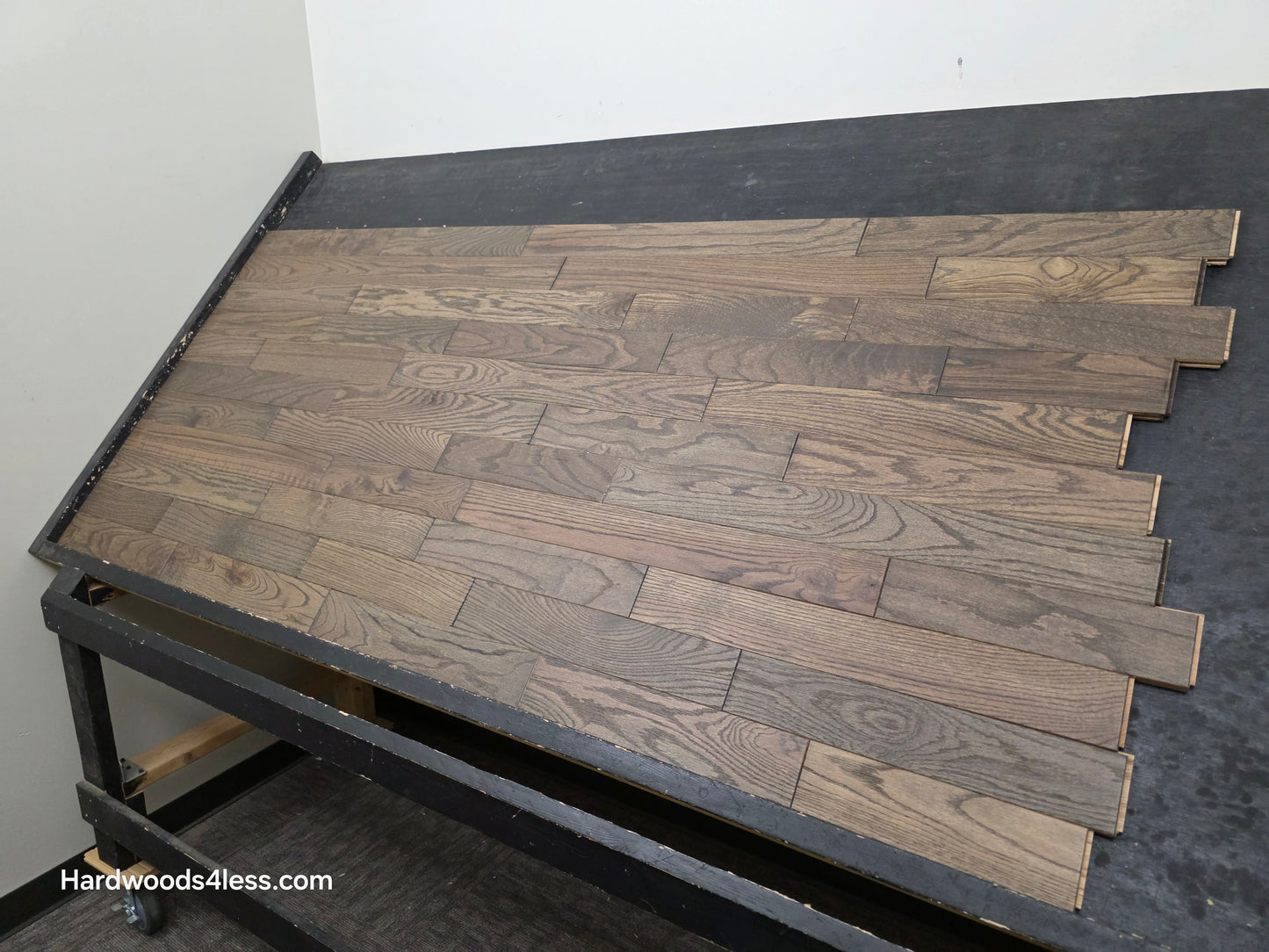 3 1/4" x 3/4" Solid Red Oak Coal Hardwood Flooring. Shown on a black shooting table. Shot from the right side. 