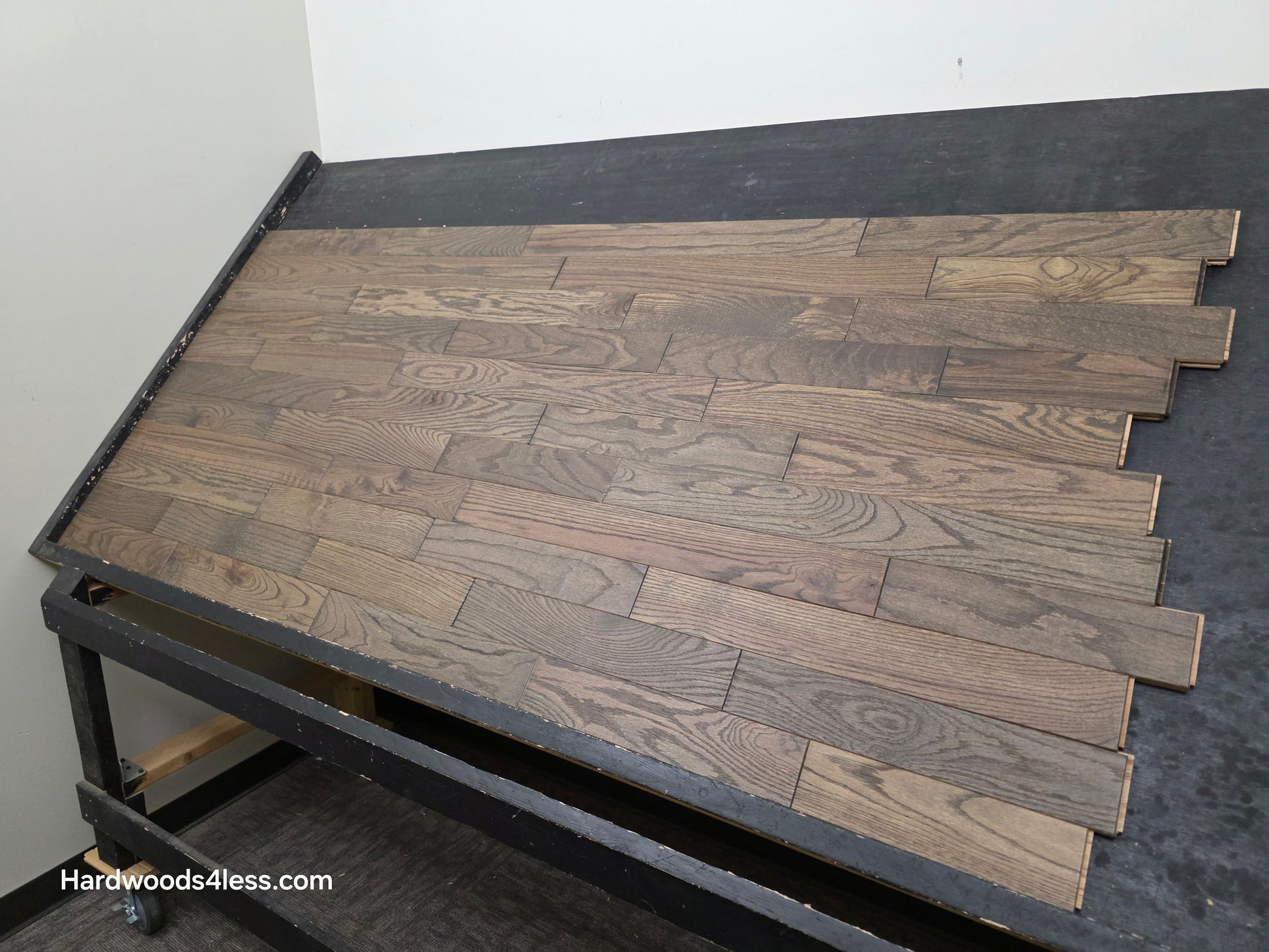 3 1/4" x 3/4" Solid Red Oak Coal Hardwood Flooring. Shown on a black shooting table. Shot from the right side. 