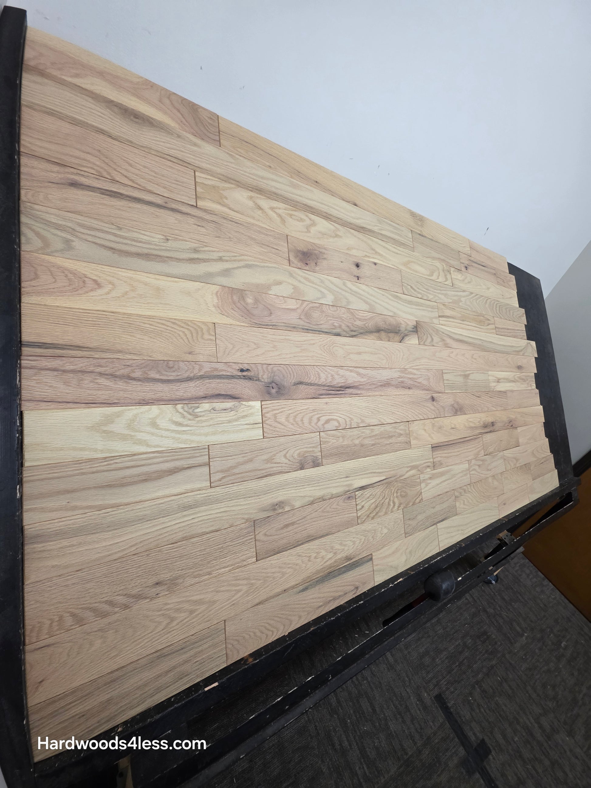 3 1/4" x 3/4" Solid Red Oak Khaki Hardwood Flooring. Shown on a black shooting table. Shot from steep left.