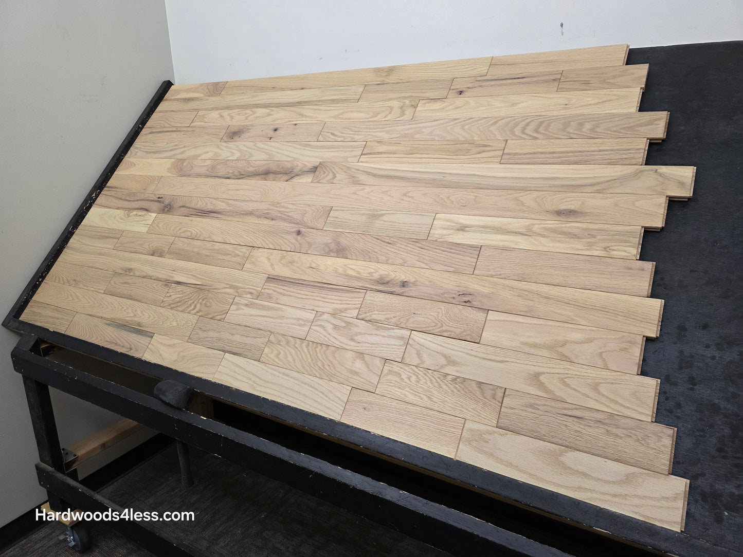 3 1/4" x 3/4" Solid Red Oak Khaki Hardwood Flooring. Shown on a black shooting table. Shot from steep right.