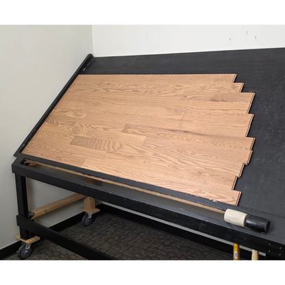 3 1/4" x 3/4" Solid Red Oak Marcy Hardwood Flooring. Shown on a black shooting table. Shot from wide right.
