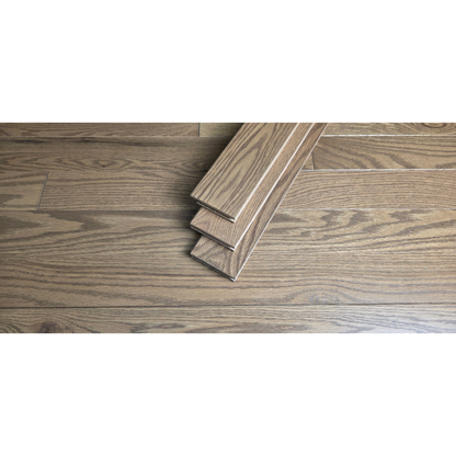 3 1/4" x 3/4" Solid Red Oak Marcy Hardwood Flooring. Shown close up with three planks of the Flooring stacked at center of the floor. 