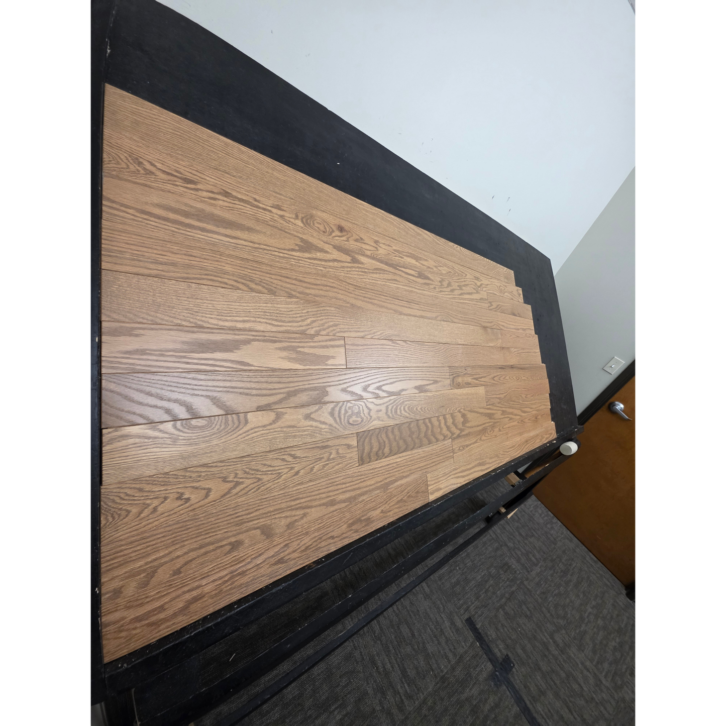 3 1/4" x 3/4" Solid Red Oak Marcy Hardwood Flooring. Shown on a black shooting table. Shot from steep left.
