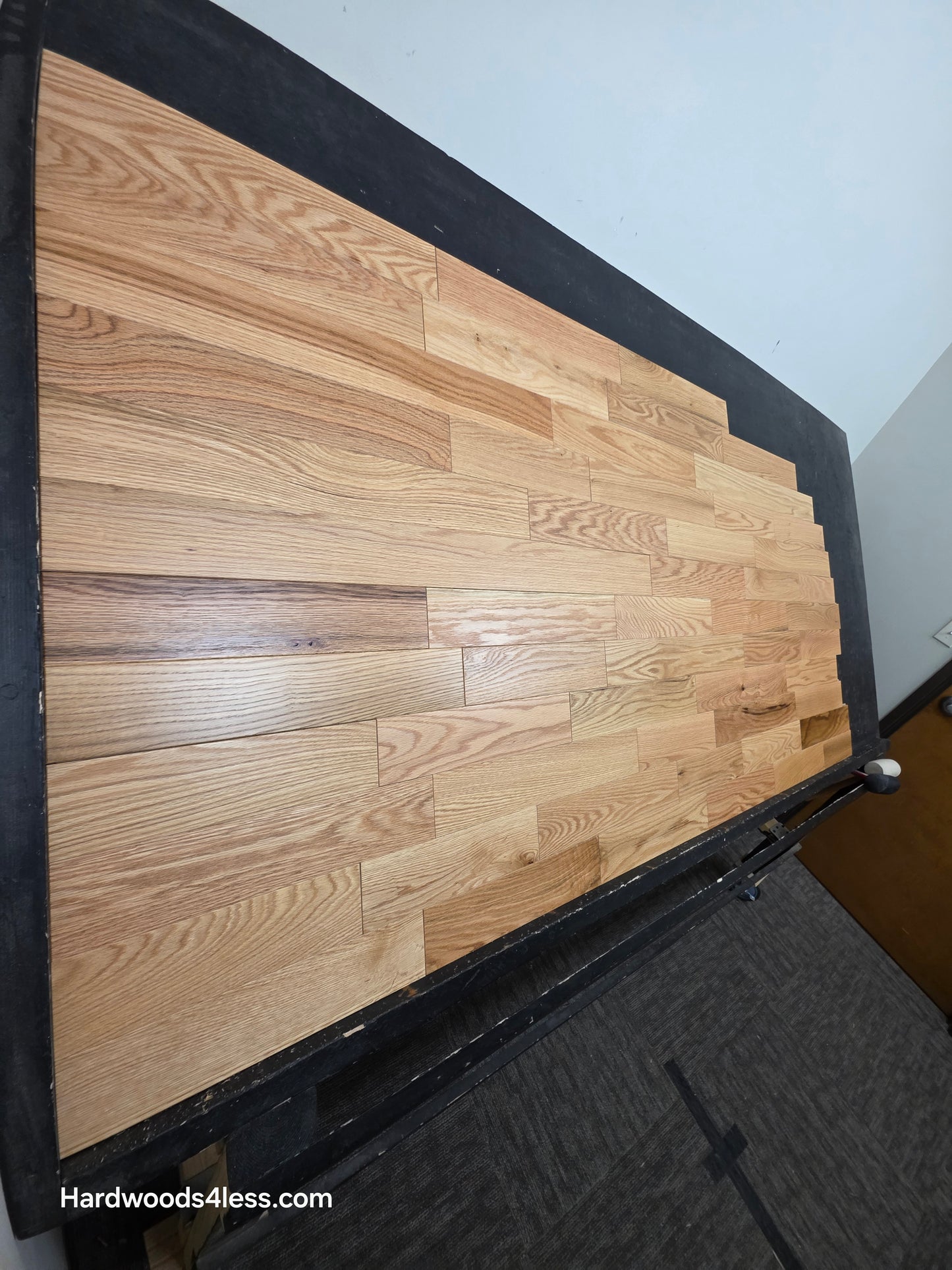 3 1/4" x 3/4" Solid Red Oak Natural Rustic Shorts Hardwood Flooring. Shown on a black shooting table. Shot from steep left. 