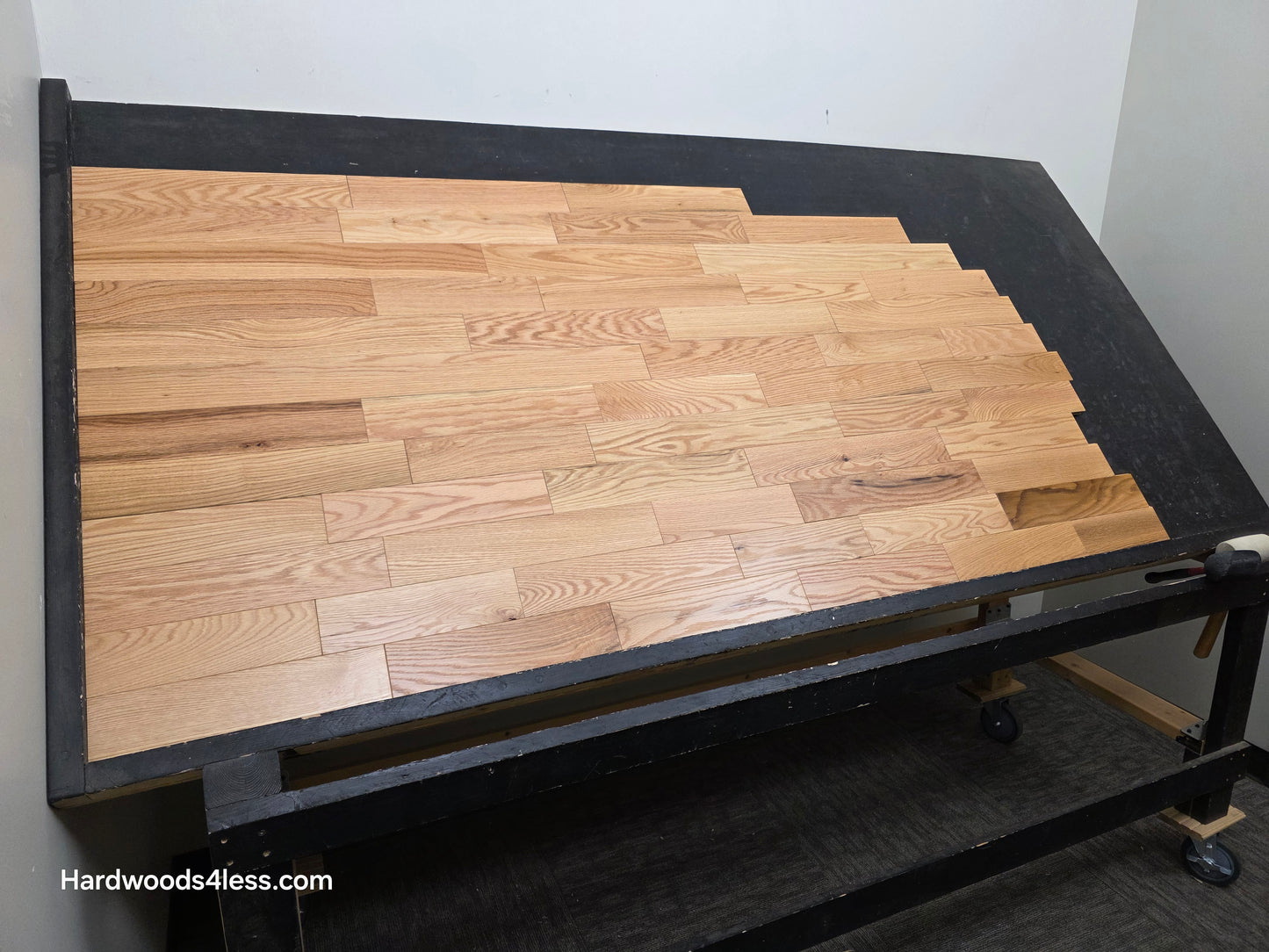 3 1/4" x 3/4" Solid Red Oak Natural Rustic Shorts Hardwood Flooring. Shown on a black shooting table. Shot from wide left.