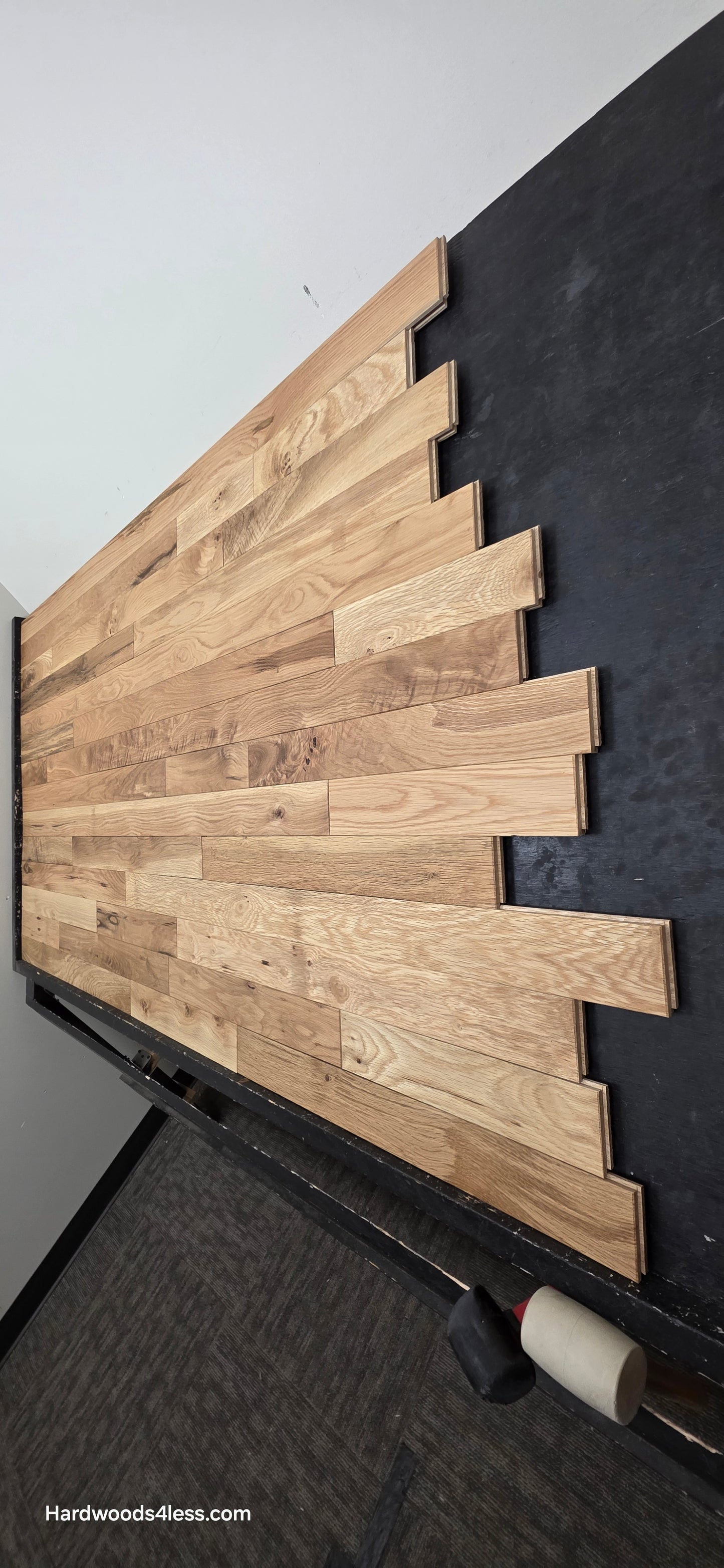 3 1/4" x 3/4" Solid White Oak Natural Character Grade Hardwood Flooring. Shown on a black shooting table. Shot steep from the right hand side. 