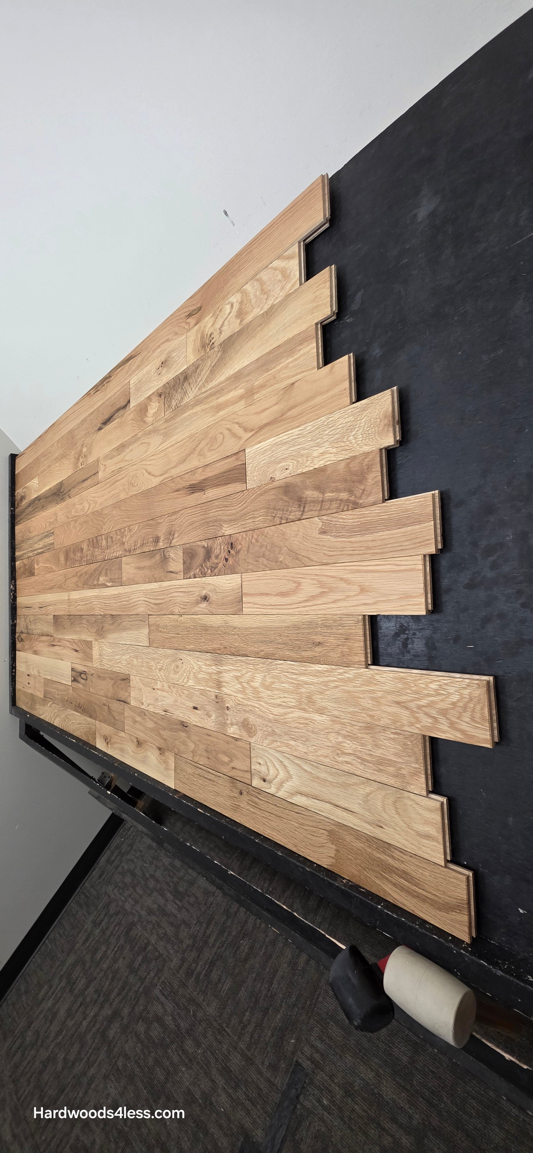 3 1/4" x 3/4" Solid White Oak Natural Character Grade Hardwood Flooring. Shown on a black shooting table. Shot steep from the right hand side. 