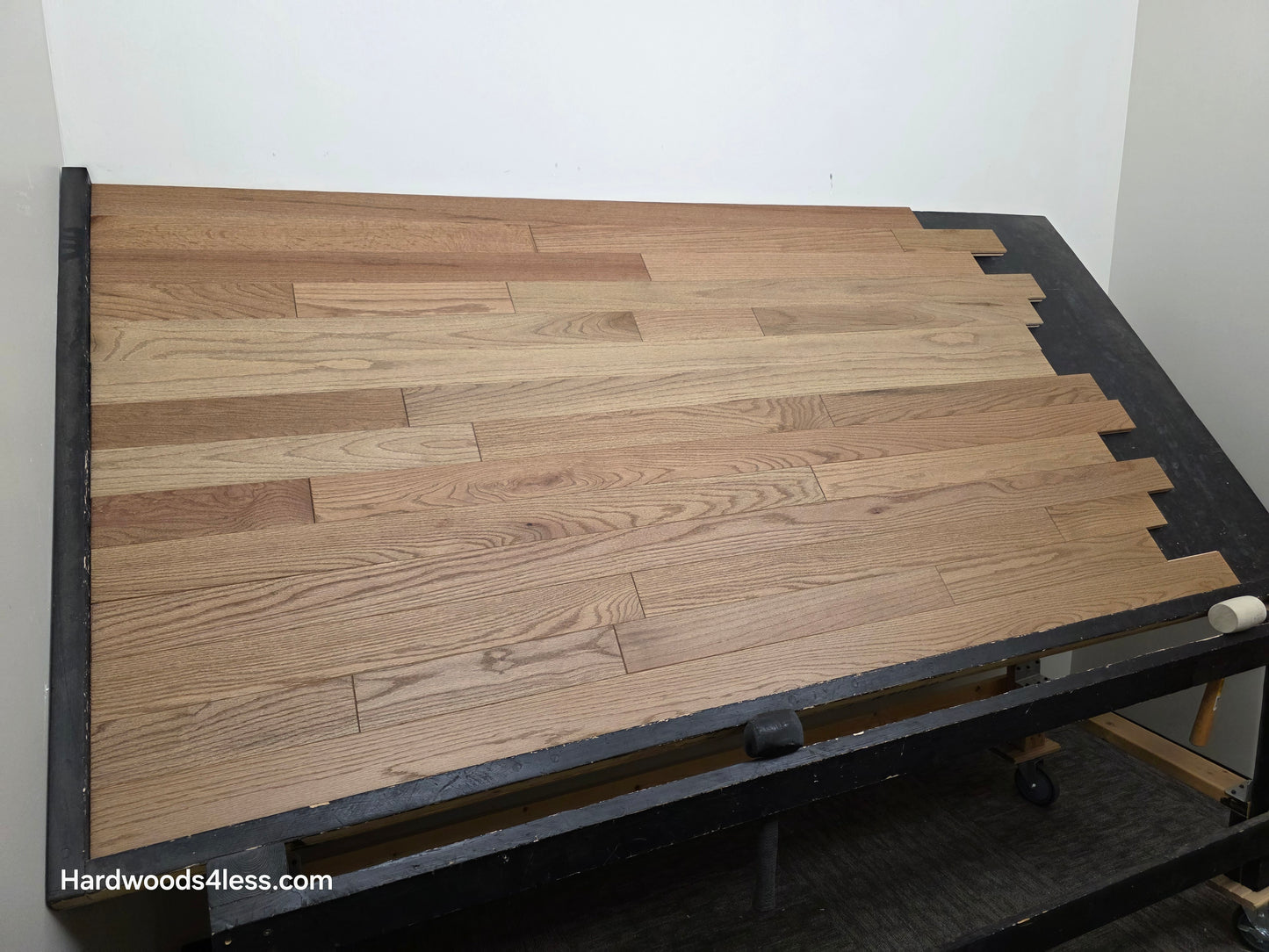 3 1/4" x 3/4" Solid White Oak Rye Hardwood Flooring. Shown on a black shooting table. Wide left shot. 