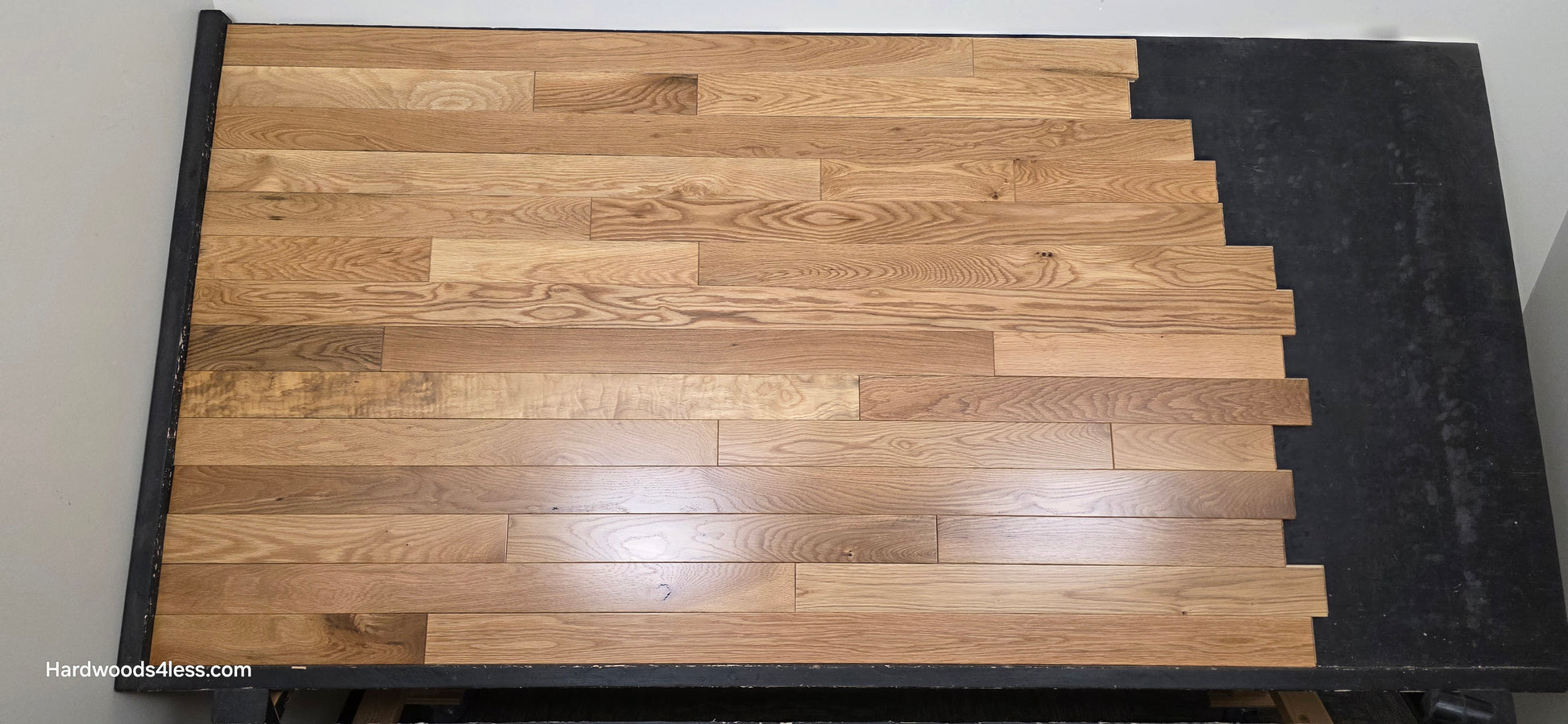 3 1/4" x 3/4" White Oak Natural Hardwood Flooring. Shown on a black shooting table. Center shot. 