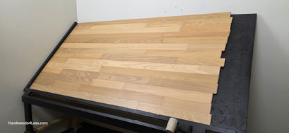 3 1/4" x 3/8" Engineered Brazilian Oak Natural Hardwood Flooring. Shown on a a black shooting table. Shot from wide right.