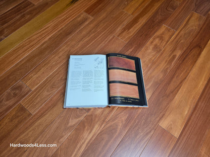 3 1/4" x 3/8" Engineered Santos Mahogany Hardwood Flooring. Shown in the center is a hardwood book. The book is open to a Mahogany page on top of the Santos Mahogany flooring.