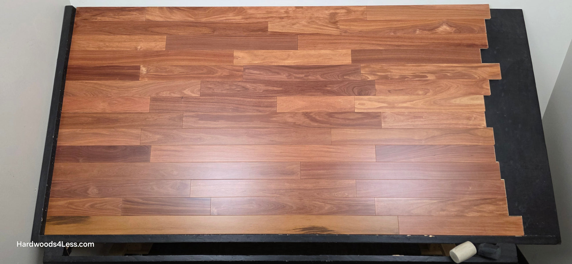 3 1/4" x 3/8" Engineered Santos Mahogany Hardwood Flooring. Shown on a black shooting table. Shot from center.