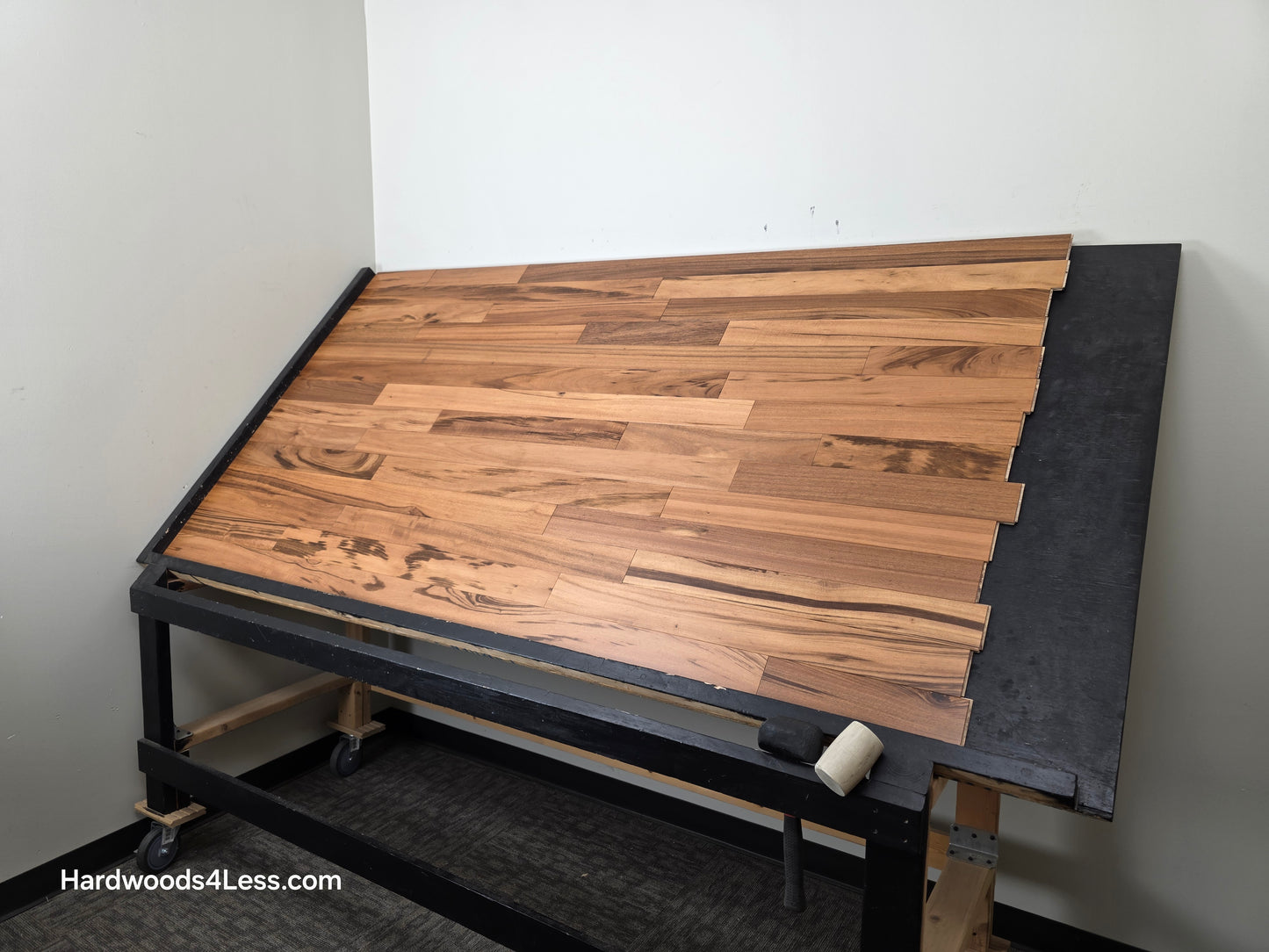 3 1/4" x 3/8" Engineered Tigerwood Hardwood Flooring. Shown on a black shooting table. Shot from wide right.