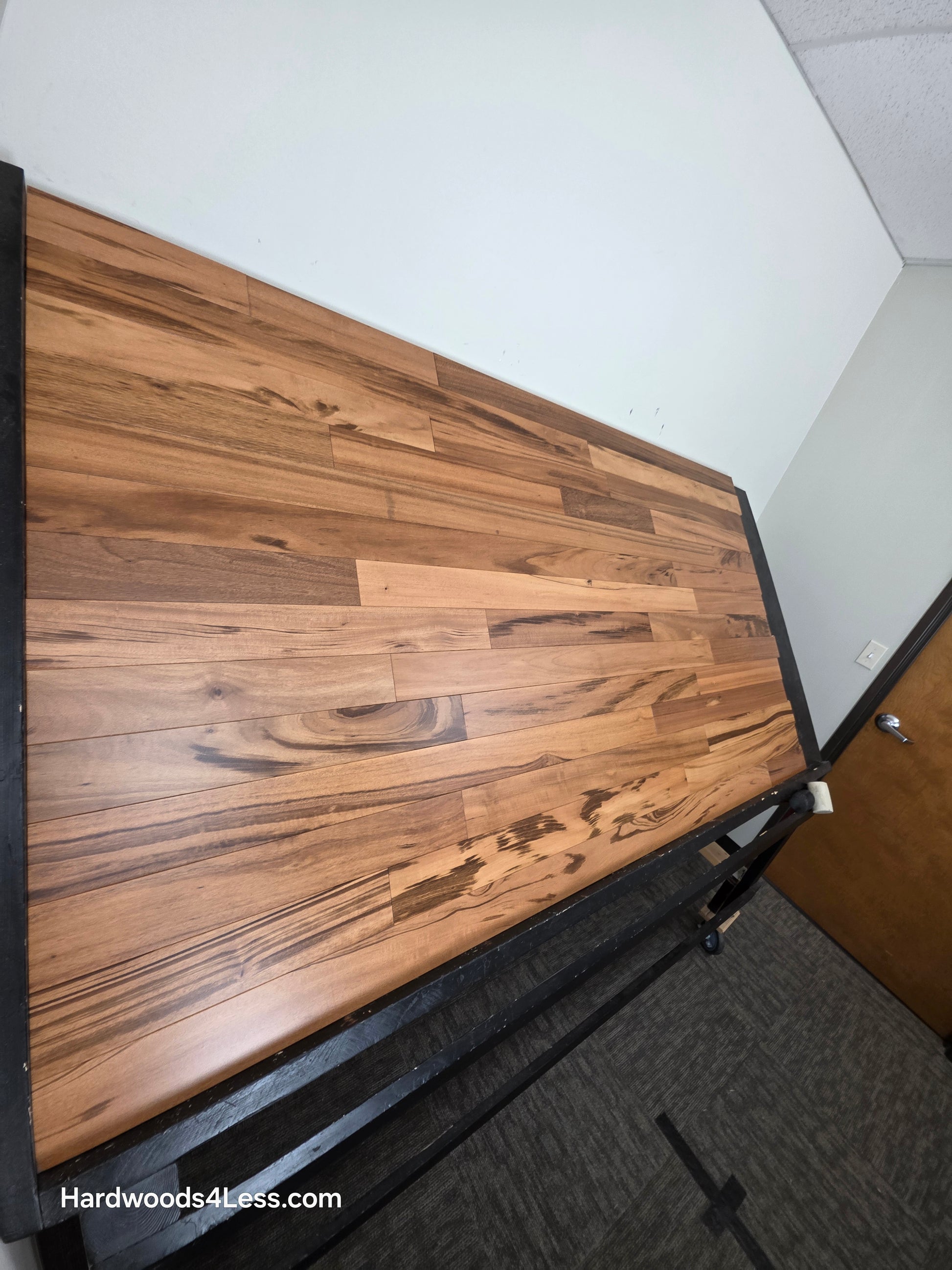 3 1/4" x 3/8" Engineered Tigerwood Hardwood Flooring. Shown on a black shooting table. Shot from steep left. 