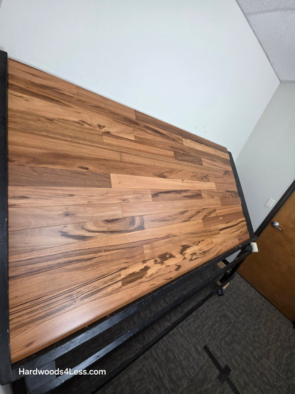 3 1/4" x 3/8" Engineered Tigerwood Hardwood Flooring. Shown on a black shooting table. Shot from steep left. 