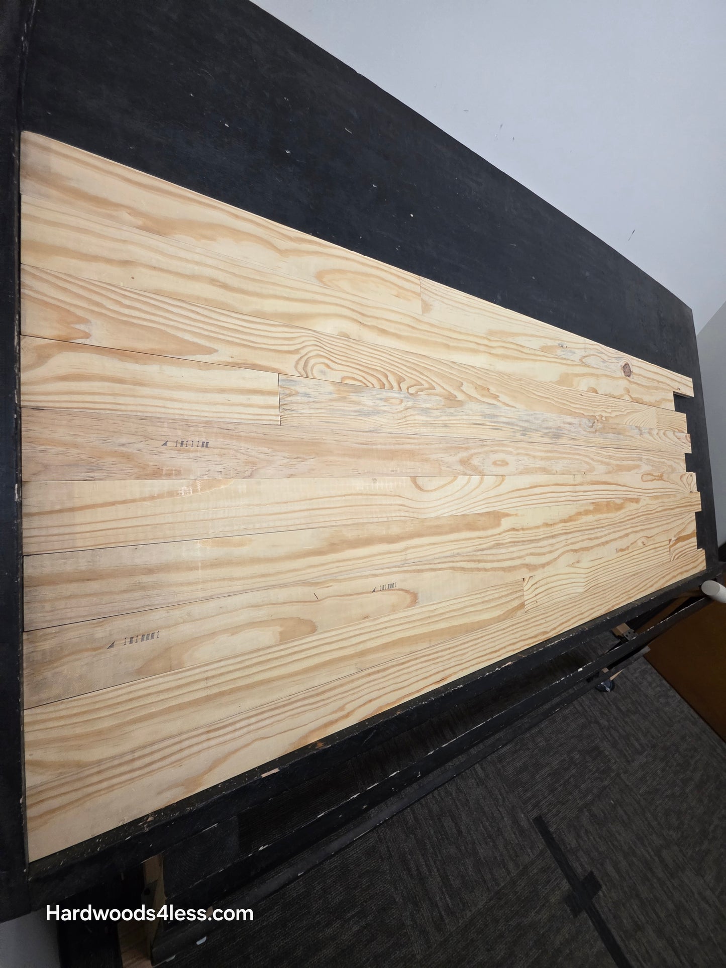 3 1/8" x 3/4" Unfinished Southern Yellow Pine Solid Hardwood Flooring. Shown on a black shooting table shot from the left hand side. 