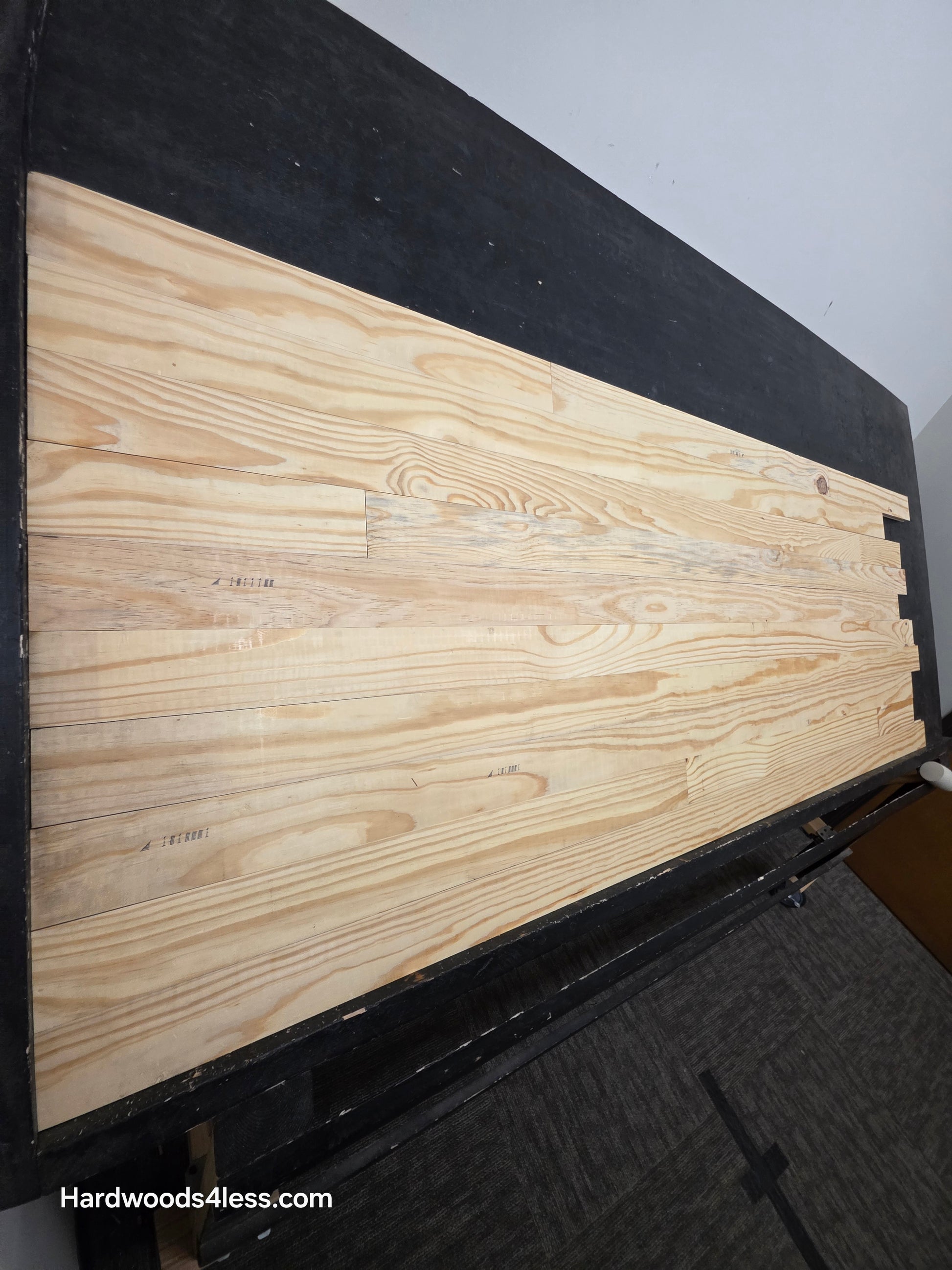 3 1/8" x 3/4" Unfinished Southern Yellow Pine Solid Hardwood Flooring. Shown on a black shooting table shot from the left hand side. 