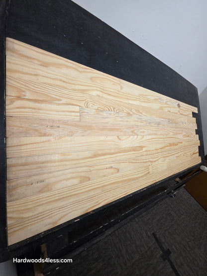 3 1/8" x 3/4" Unfinished Southern Yellow Pine Solid Hardwood Flooring. Shown on a black shooting table shot from the left hand side. 