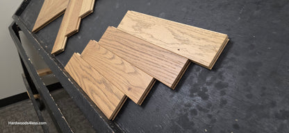 3" x 15" x 3/4" Solid White Oak Newport Herringbone Hardwood Flooring. Shown on a black shooting table. 4 tiles stacked on top of each other. 