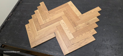 3" x 15" x 3/4" Solid White Oak Newport Herringbone Hardwood Flooring. Shown on a black shooting table. Shot low wide right. 