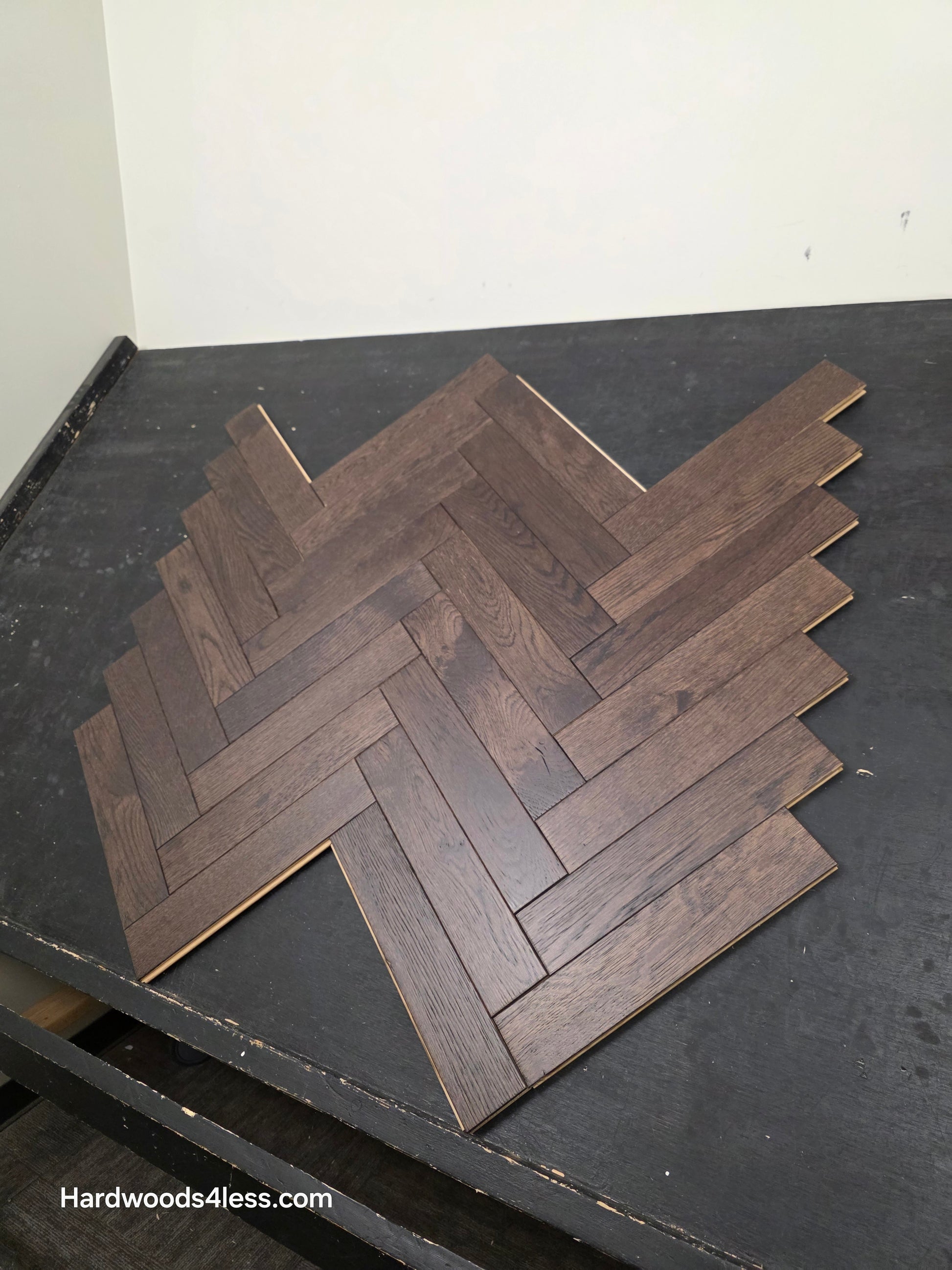 3" x 15" x 3/4" Solid White Oak Salem Herringbone Hardwood Flooring. Shown on a black shooting table. Close up.
