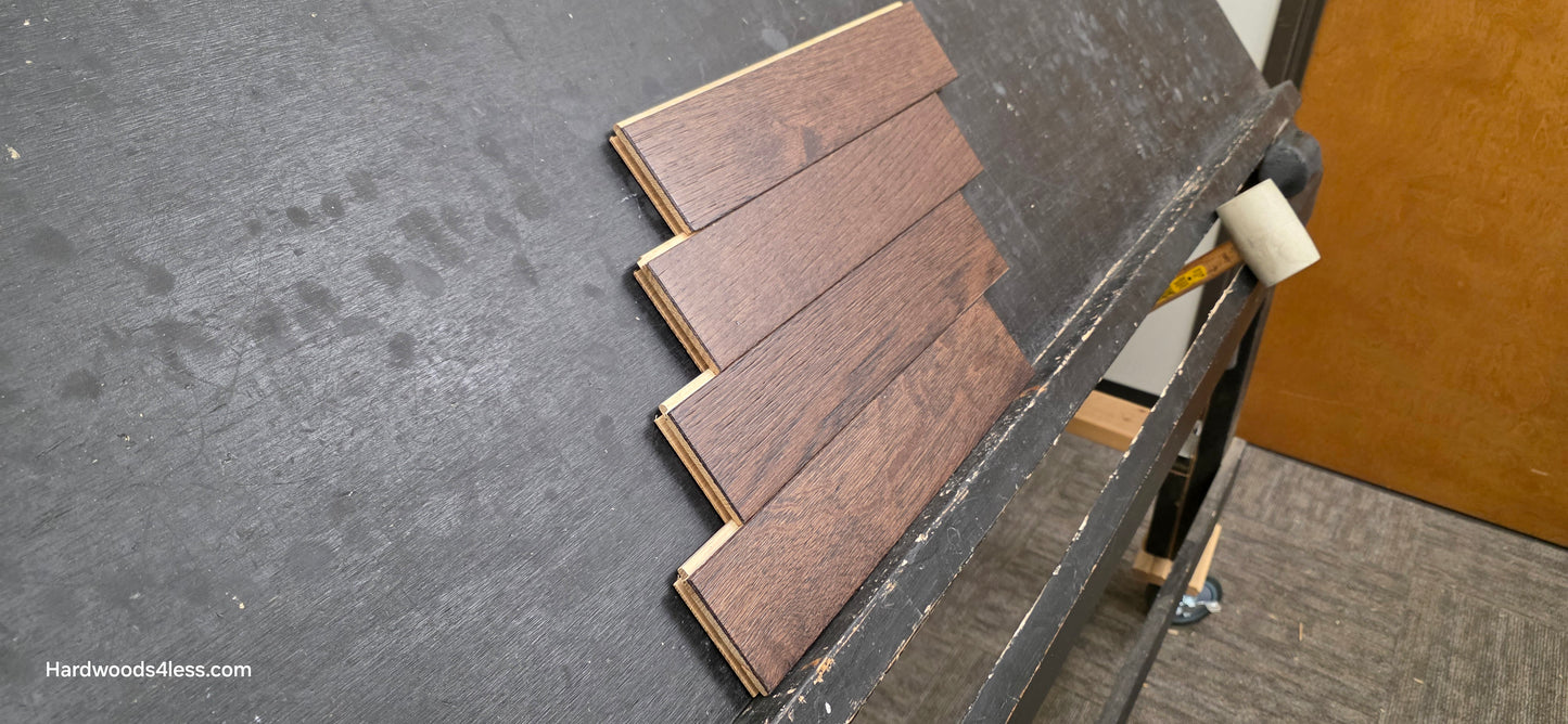 3" x 15" x 3/4" Solid White Oak Salem Herringbone Hardwood Flooring. Shown on a black shooting table. Close up of 4 tiles stacked on top of each other.  