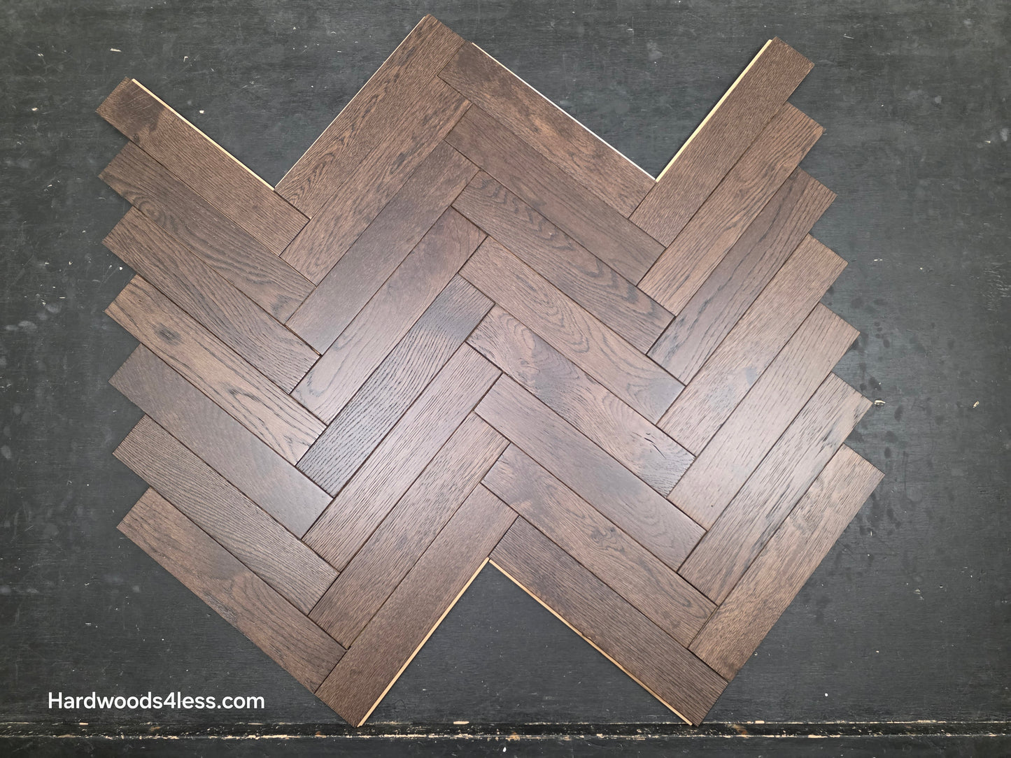 3" x 15" x 3/4" Solid White Oak Salem Herringbone Hardwood Flooring. Shown on a black shooting table. Close up.