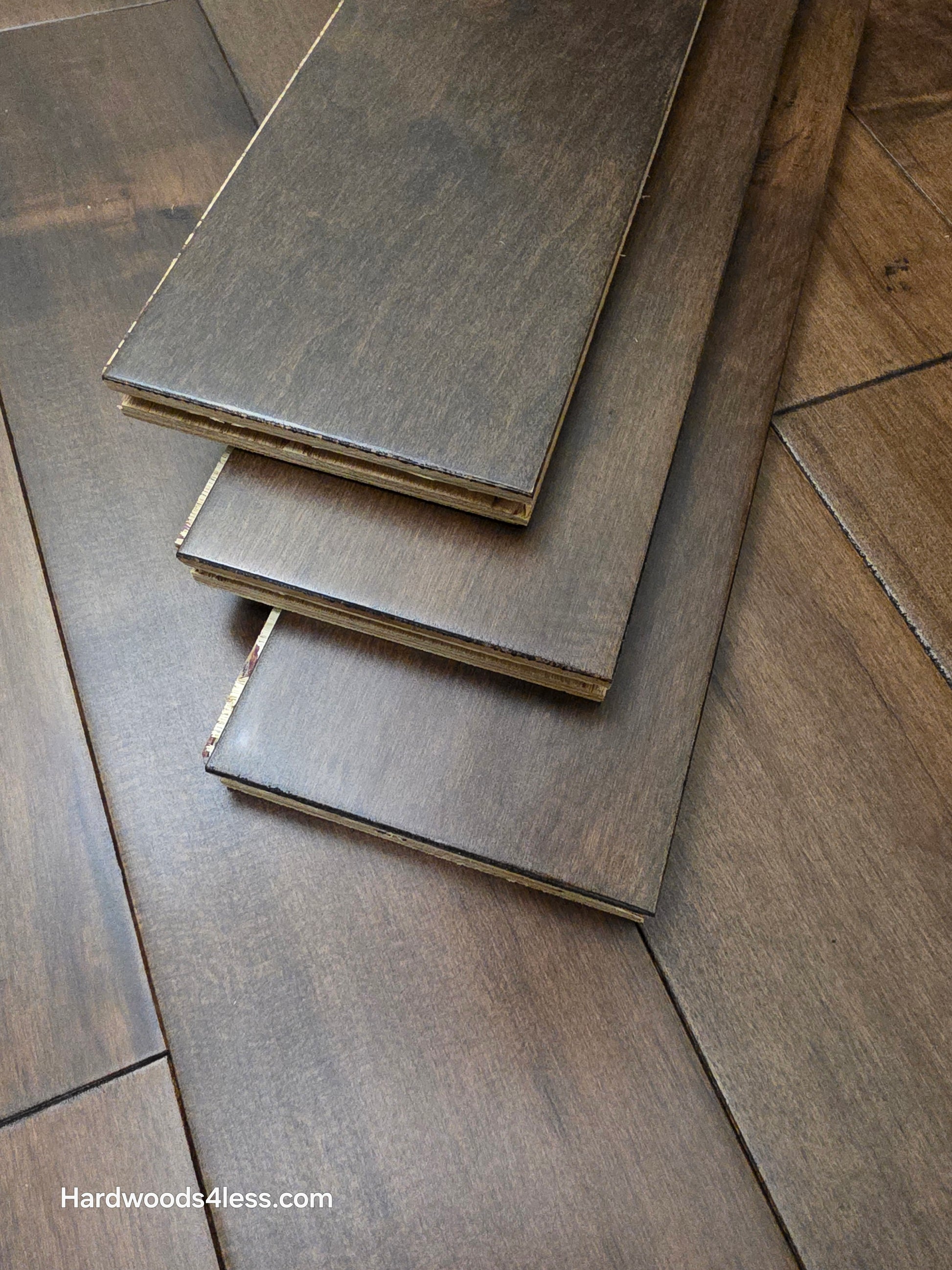 4 5/16" x 5/8" Engineered Maple Cabana Hardwood Flooring. Shown as three planks stacked atop the wood flooring.