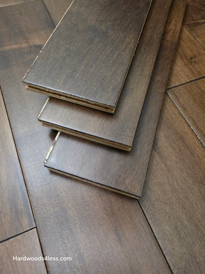 4 5/16" x 5/8" Engineered Maple Cabana Hardwood Flooring. Shown as three planks stacked atop the wood flooring.
