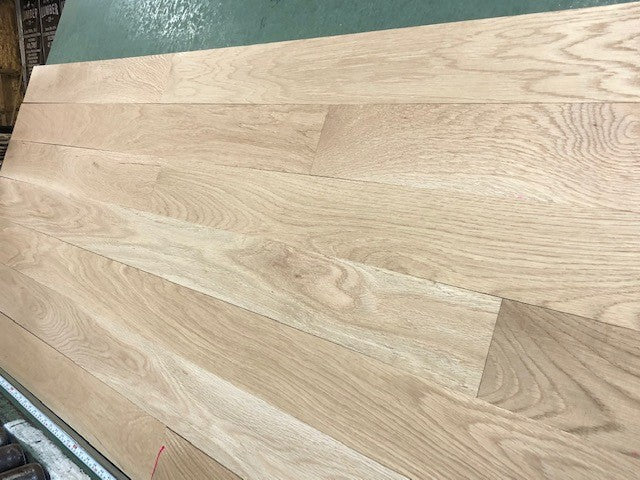 4 x 3/4 Unfinished White Oak Select & Better Solid Hardwood Flooring zoomed in with a green backer 