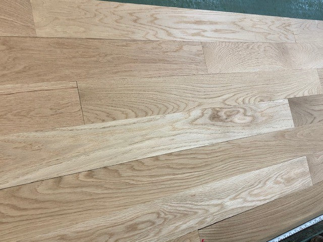 4 x 3/4 Unfinished White Oak Select & Better Solid Hardwood Flooring shown on a green shooting table