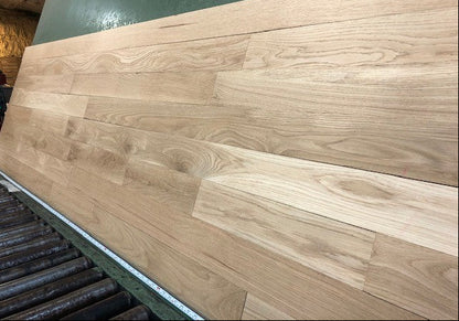 4 x 3/4 Unfinished White Oak Select & Better Solid Hardwood Flooring right angle on a green shooting rack with black rollers 