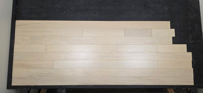 4" x 3/4" Solid Brazilian Oak Nevoa Hardwood Flooring shown on a black racking table head on 