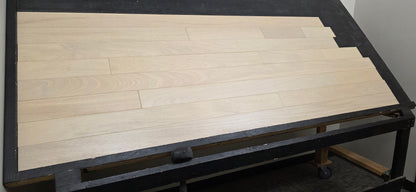 4" x 3/4" Solid Brazilian Oak Nevoa Hardwood Flooring shown on a black racking table from the left side
