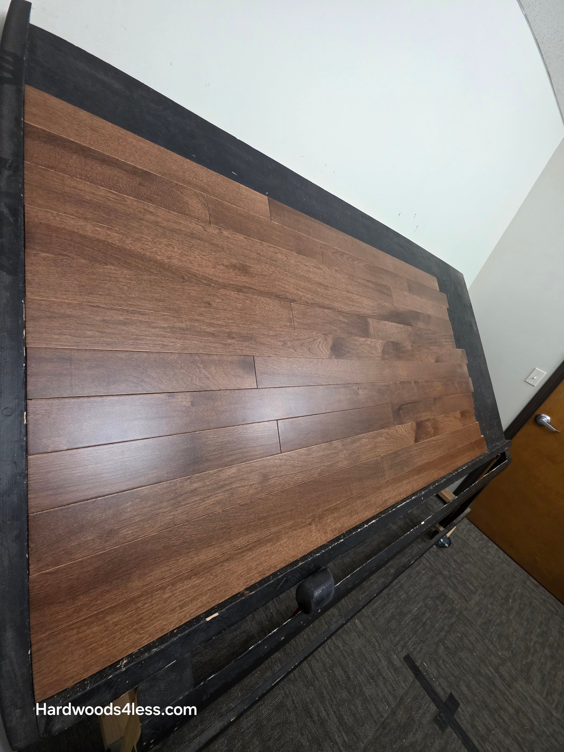 4" x 3/4" Solid Hickory Cortado Hardwood Flooring. Shown on a black shooting table. shot from steep left. 