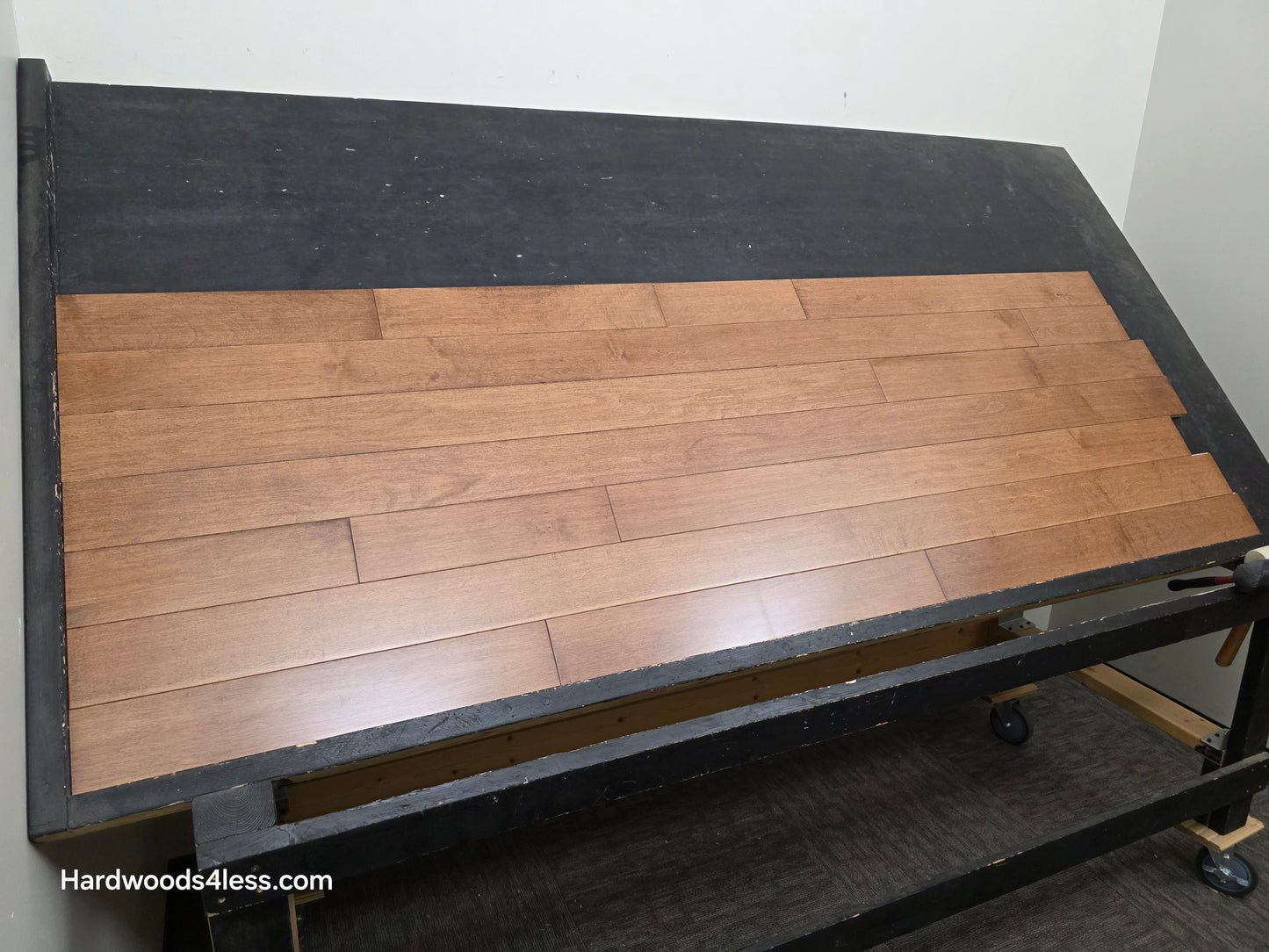 4" x 3/4" Solid Maple Hazelnut Hardwood Flooring. Shown on a black shooting table. Shot from wide left
