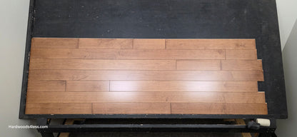 4" x 3/4" Solid Maple Hazelnut Hardwood Flooring. Shown on a black shooting table. Shot from center.