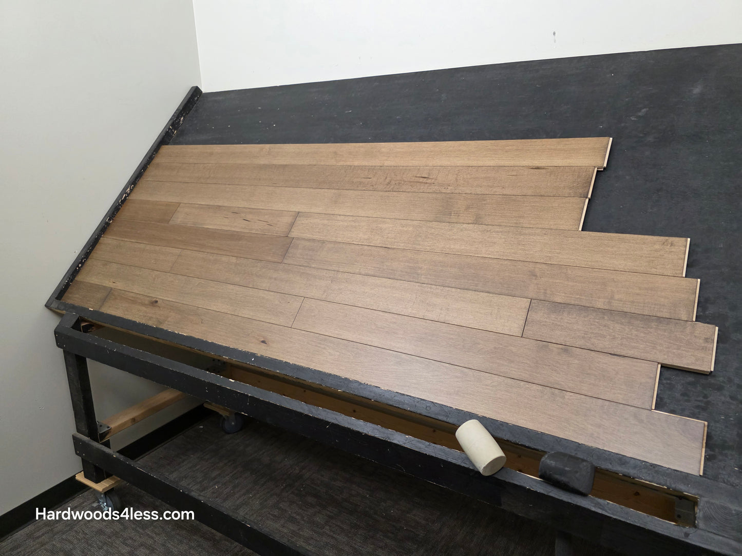 4" x 3/4" Solid Maple Sandpiper Hardwood Flooring. Shown on a black shooting table. shot from the right side. 
