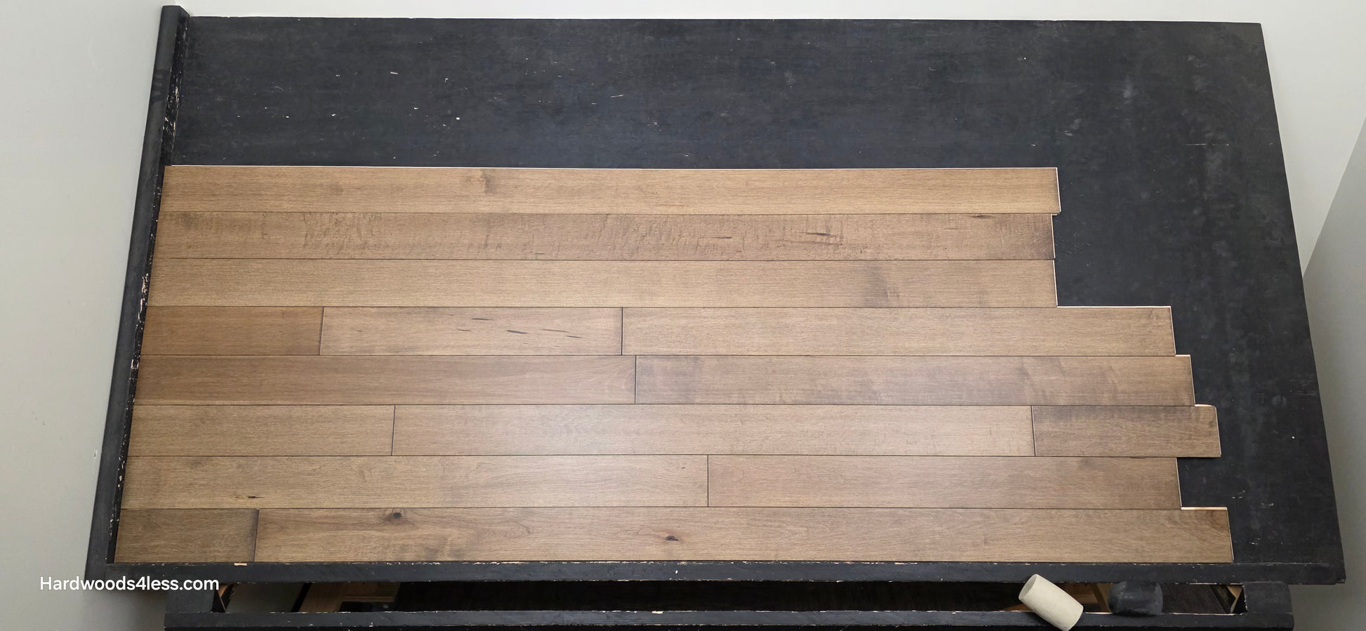 4" x 3/4" Solid Maple Sandpiper Hardwood Flooring. Shown on a black shooting table. Shot from center. 