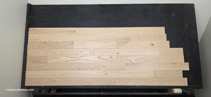 4" x 3/4" Solid Red Oak Doe Hardwood Flooring. Shown on a black shooting table. Shot from center. 